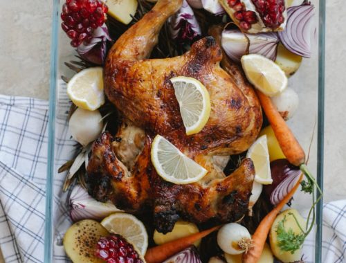 grilled whole chicken with vegetables and fruits in glass bowl